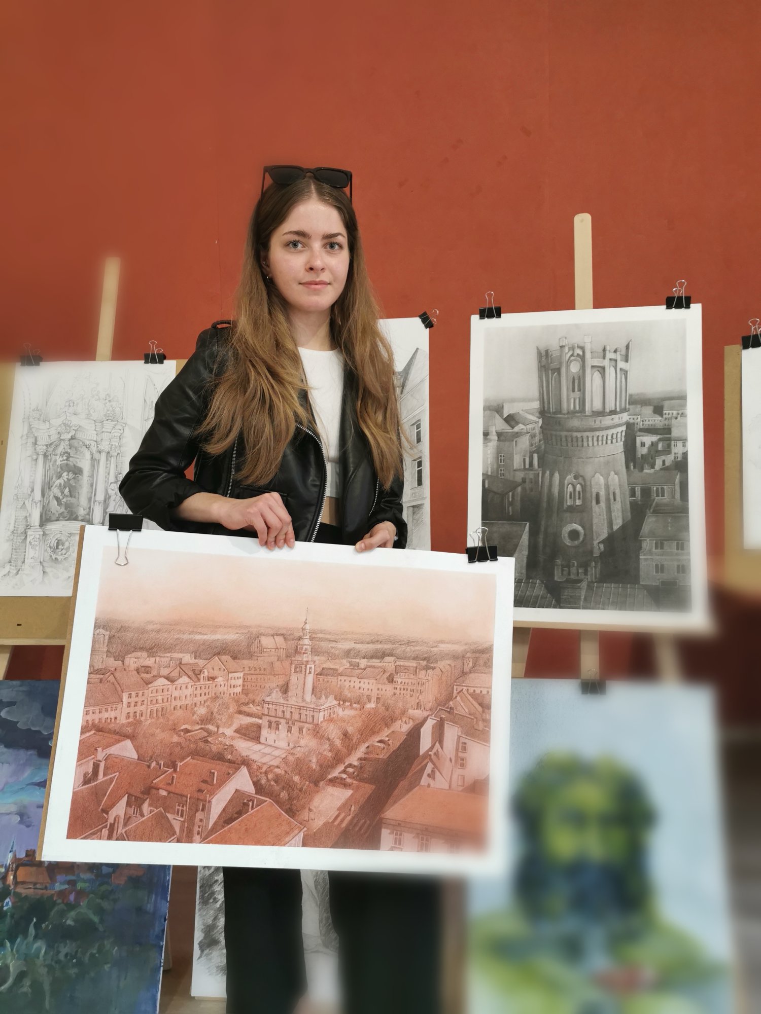 Studentka trzymająca w ręku swoją pracę
