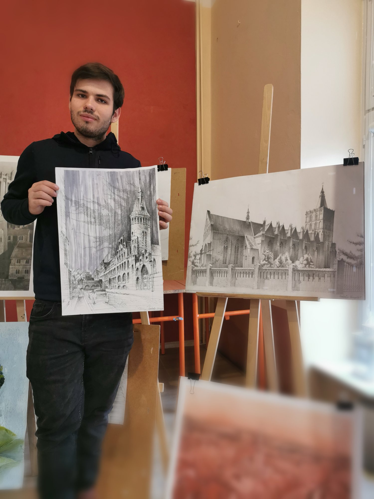Student trzymający w ręku swoją pracę