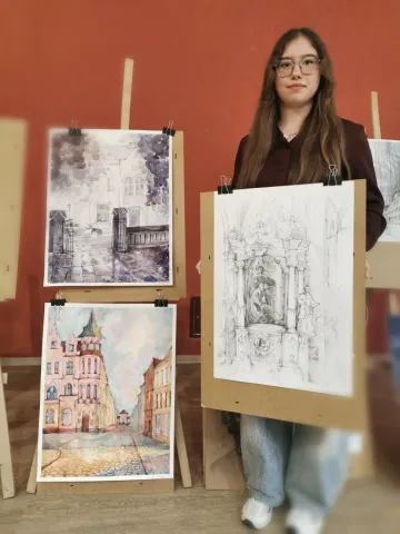 Studentka trzymająca w ręku swoją pracę