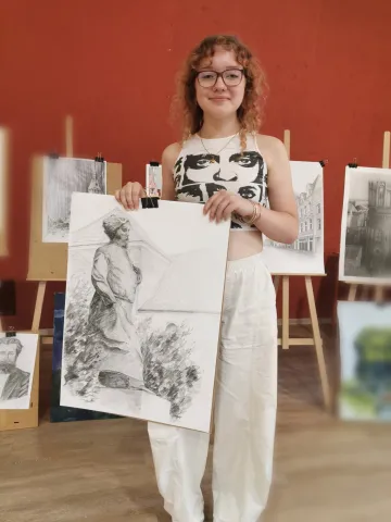 Studentka trzymająca w ręku swoją pracę